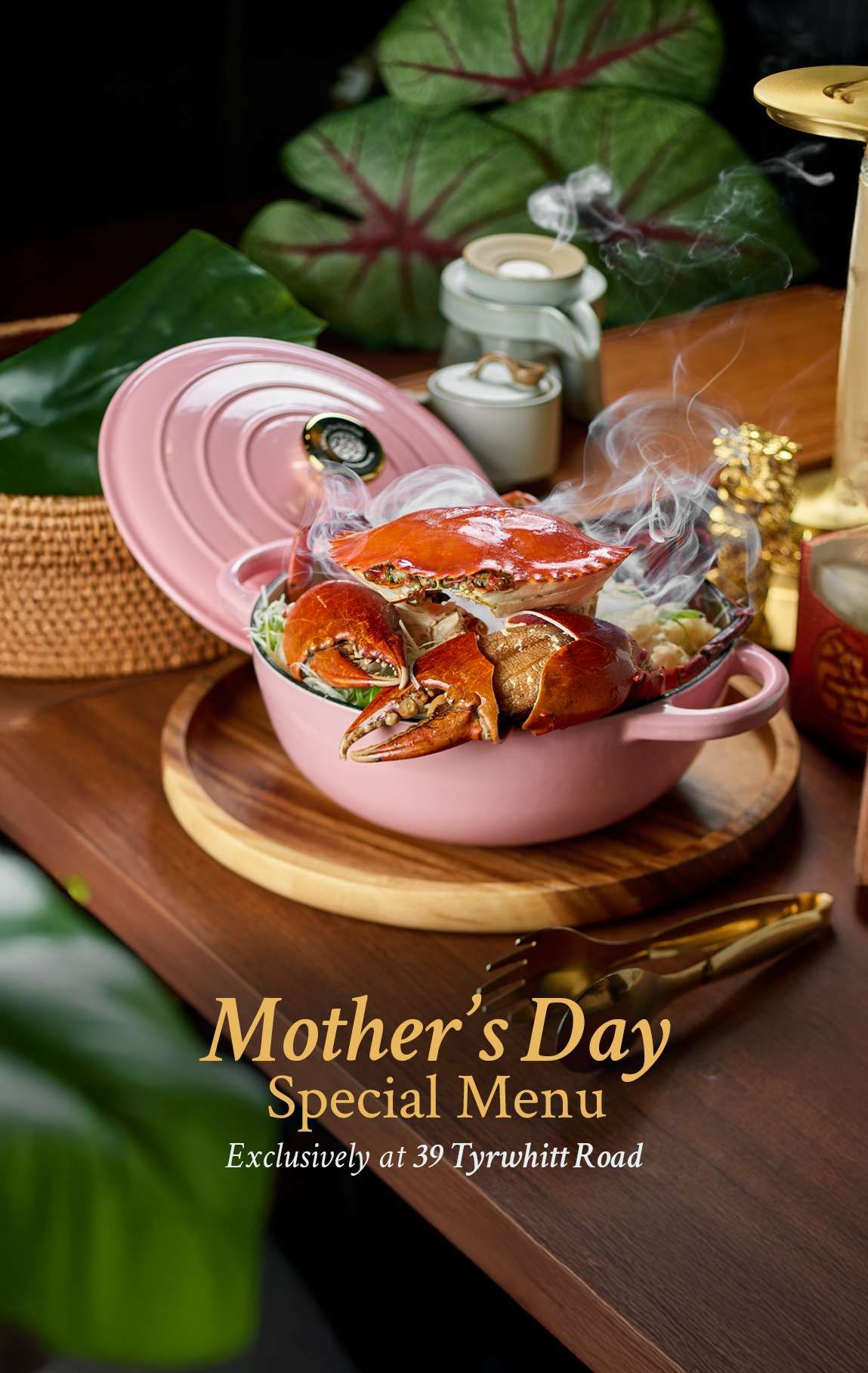 A whole crab on glutinous rice steaming in a pink cast-iron pot on a wooden board, with a Mother's Day Special Menu caption.
